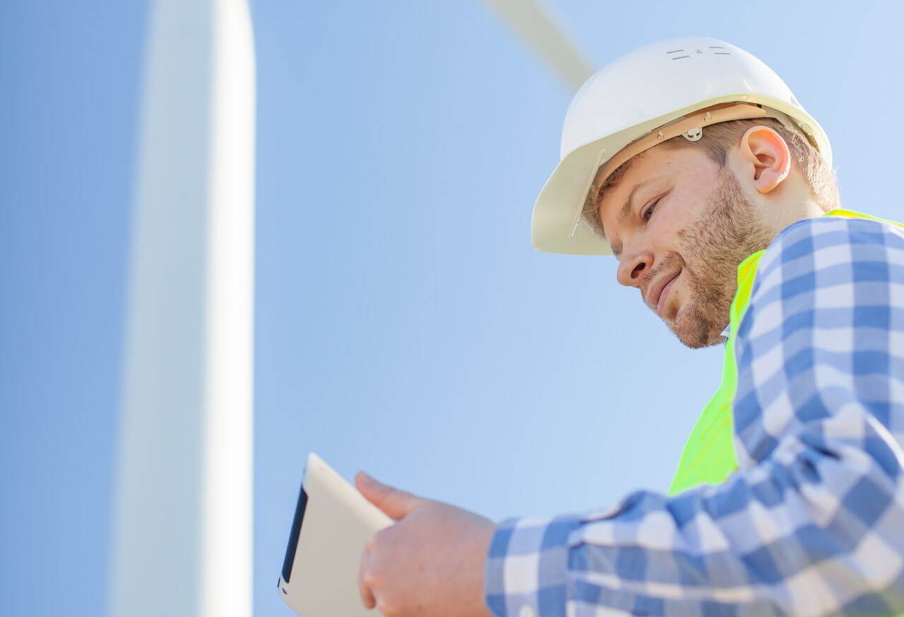 young engineer is checking on wind turbine energy production